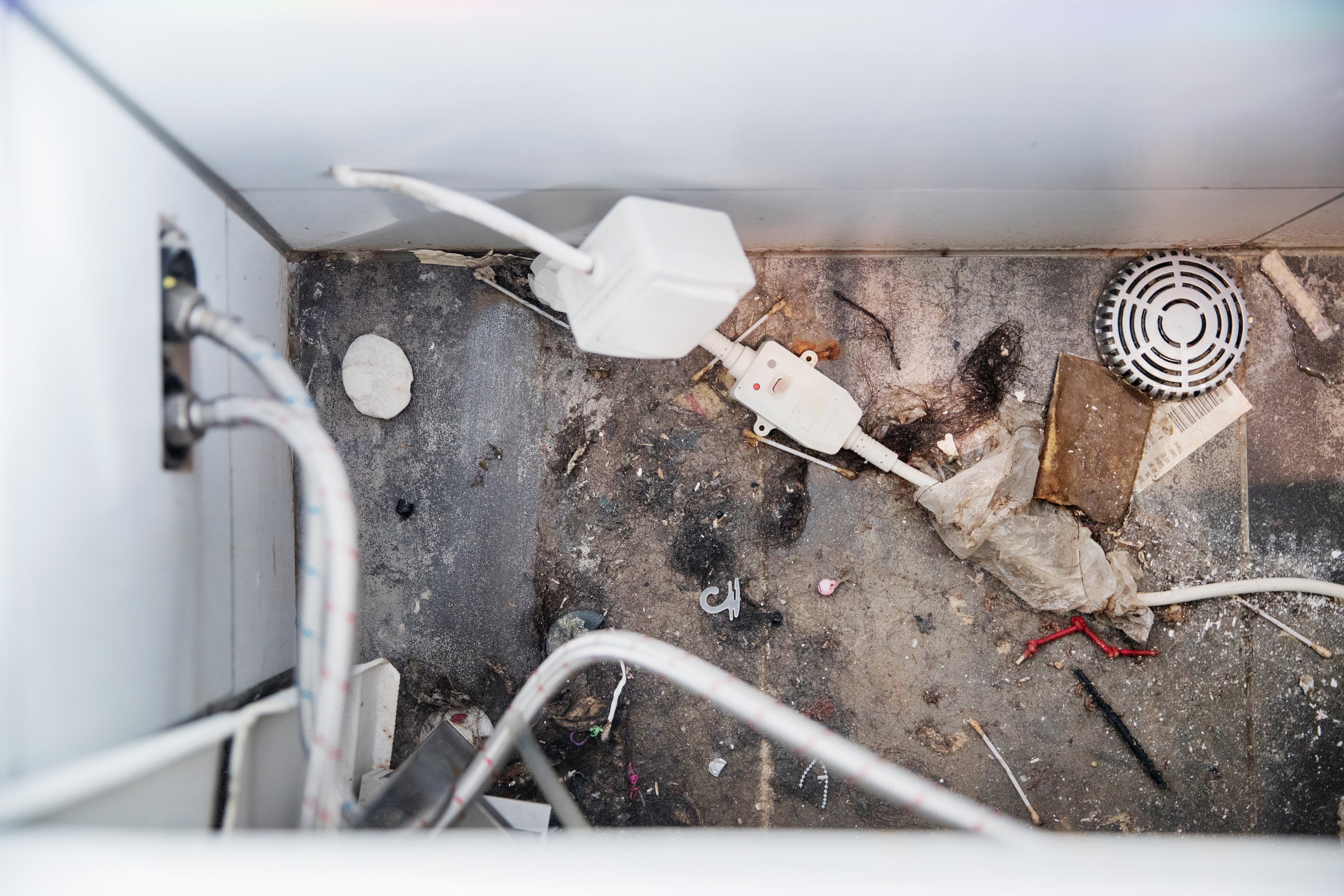 LIVSFARLIG: Slik ser badet ut når man drar bort badekaret.  Usikrede elektriske ledninger overalt gjør at det er farlig  å ta seg en dusj eller et bad.