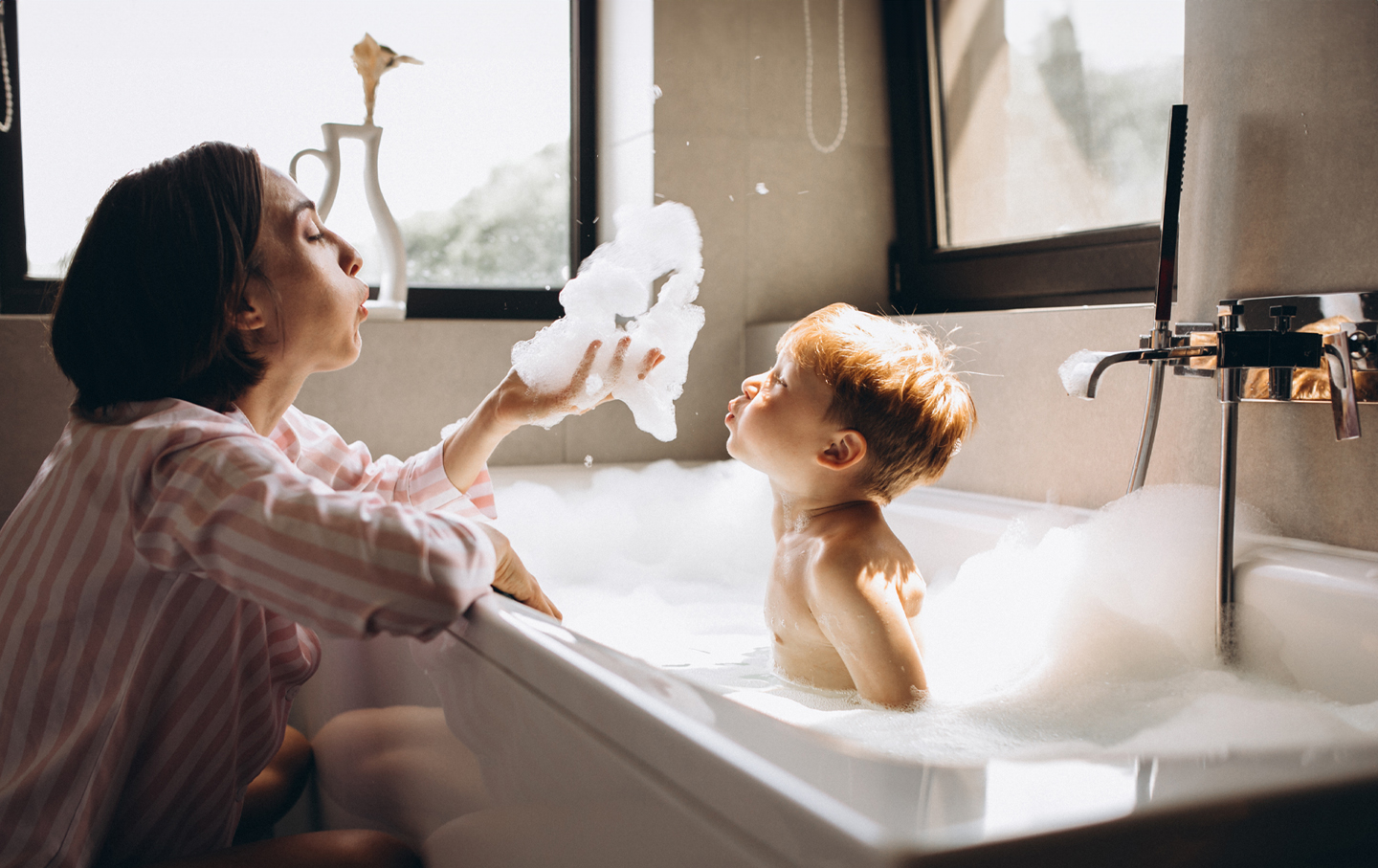 En mor med barn som bader i badekar
