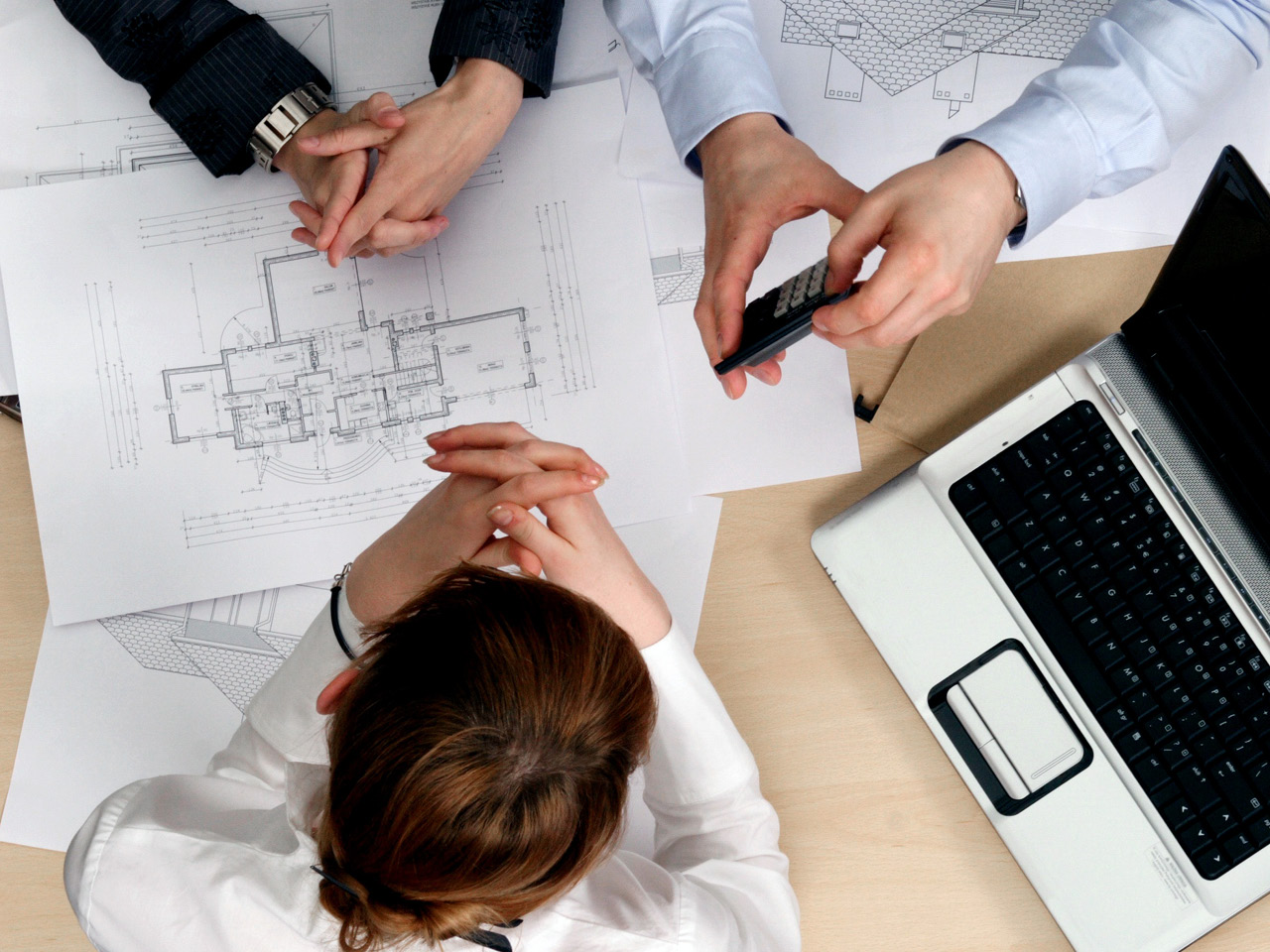 3 mennesker ser på plantegninger